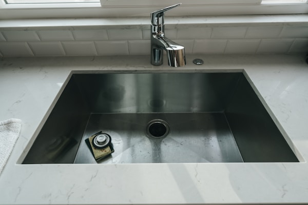 Modern kitchen sink and faucet representing residential plumbing services